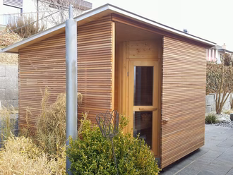 aussensauna-holzfassade-rhombus-schalung-pultdach-schiebetür-dunkles-holz-garten-sauna