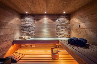 designsauna-in-dunklem-holz-mit-farblicht-und-glasfront-2