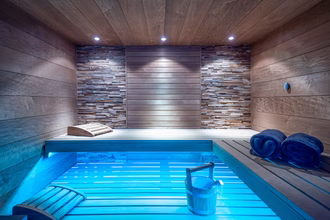 exklusive-sauna-in-dunklem-holz-mit-farblicht-und-glasfront-3