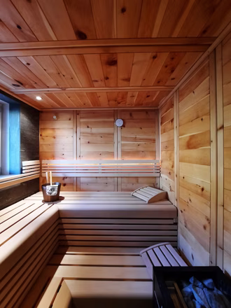 massivholzsauna-in-zirbe-mit-teilglasfront-und-integriertem-fenster-7
