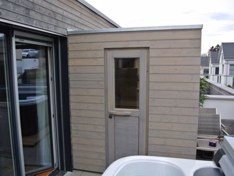 sauna-auf-terrasse-graue-schalung-vorvergraute-fassade-flachdach-an-gebaeude-041a