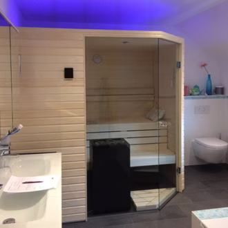 schone-sauna-glasecke-45-abgeschragt-beleuchtet-helles-holz-horizontal